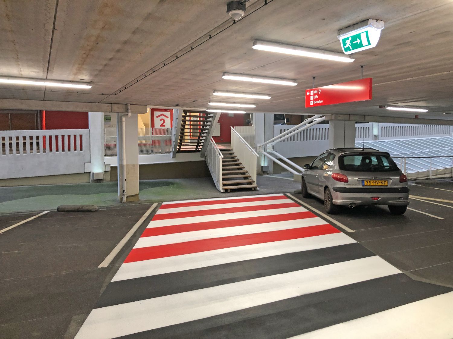 Voetgangersroutebord en belijning in parkeergarage De Opgang gemeente Amsterdam.